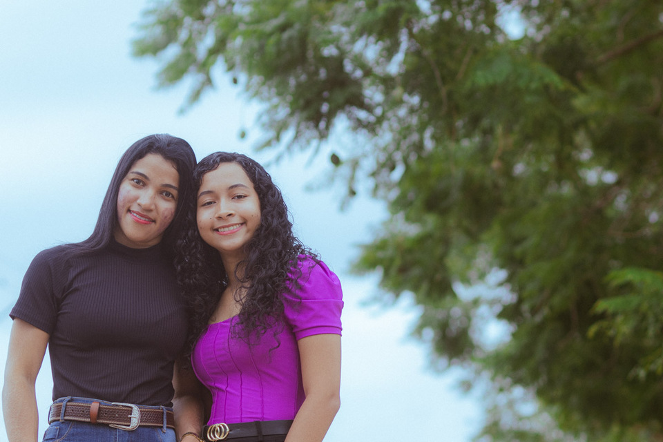 Duas mulheres lado a lado sorridentes